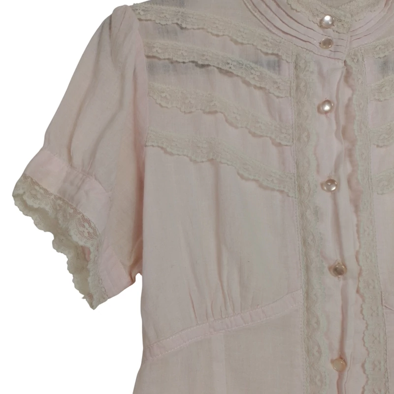 Elején gombos, derekán hátul megkötős, csipkemintás női felső