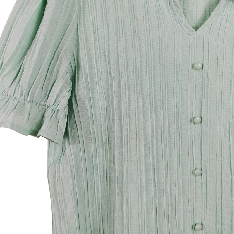 Ujja végén és nyakán fodorral, elején díszgombbal díszített női felső