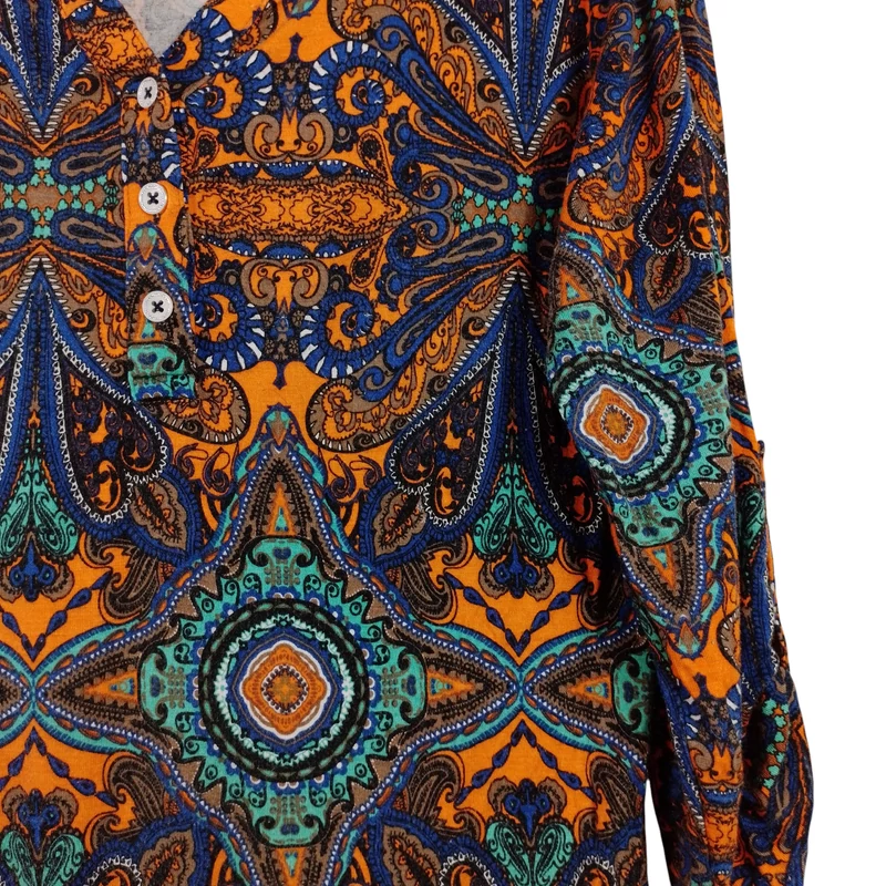 Mellrészén gombos, hátulján hosszított, mintás női felső