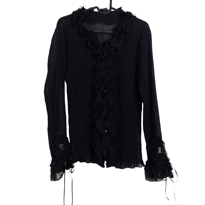 Áttetsző anyagú, elején gombos, sok fodorral díszített női felső 